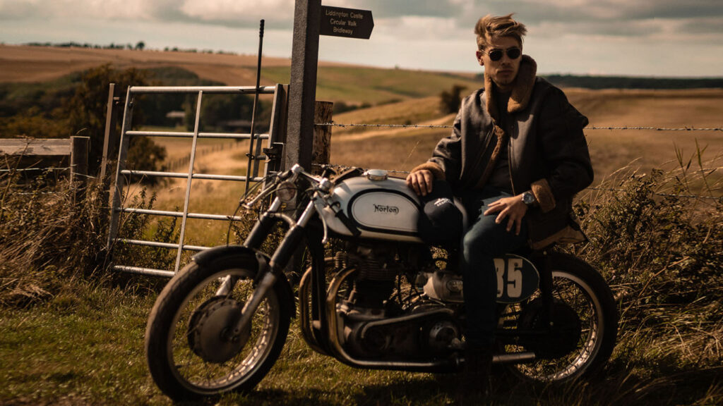 Man on motorbike parked by a field gate