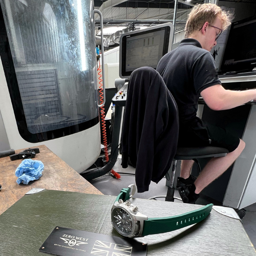 DB2 watch on watch box in office with man sitting on a chair